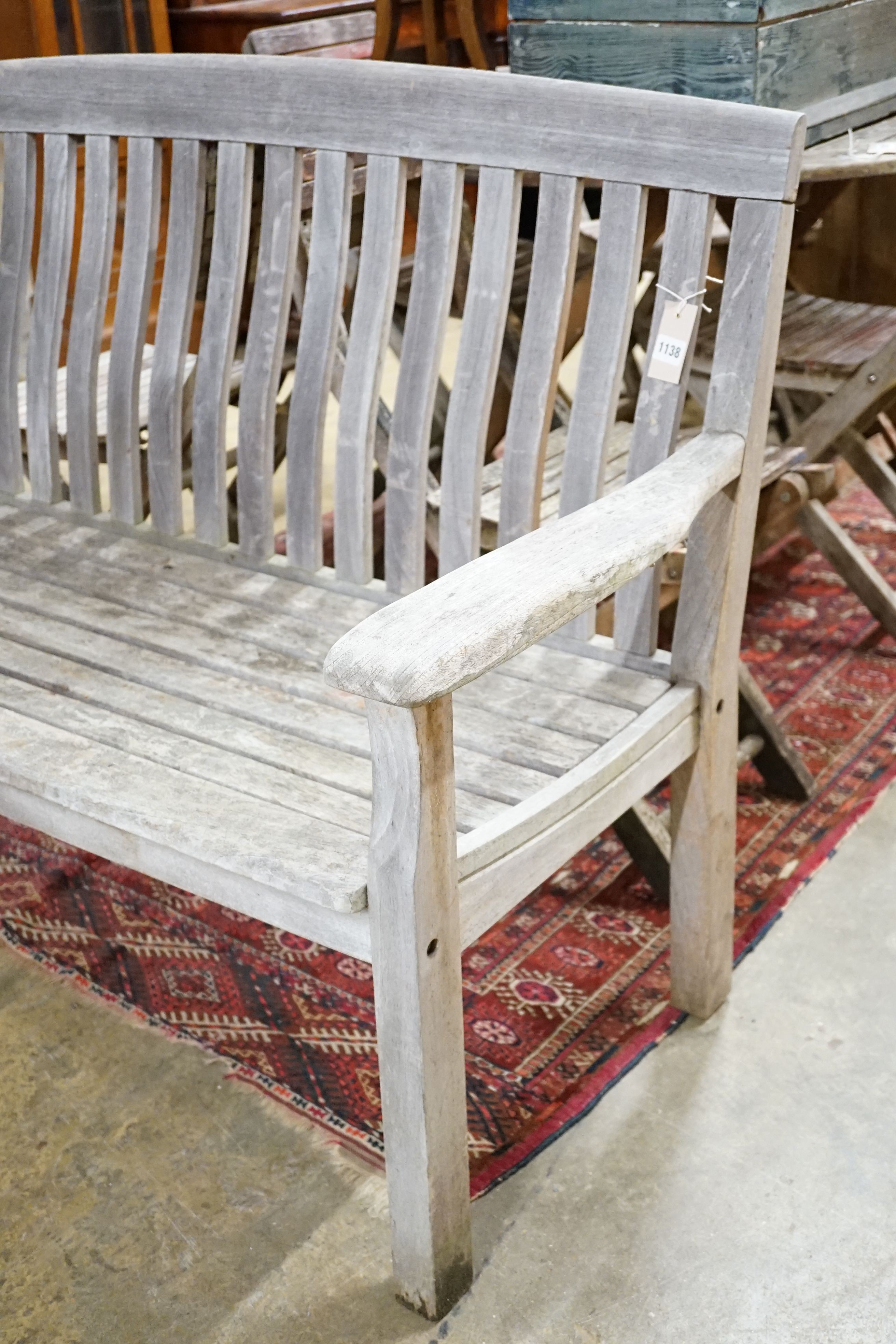 A weathered teak garden bench, length 129cm